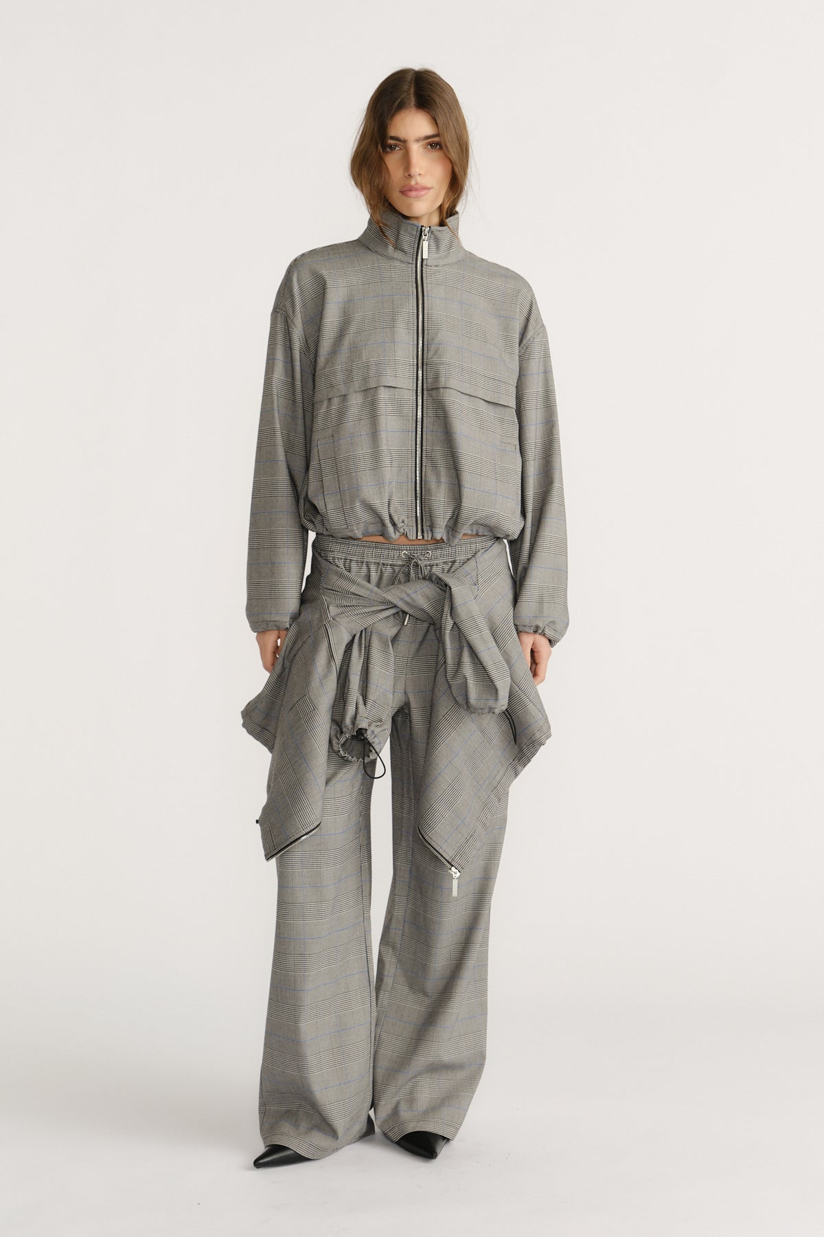 Woman wearing a relaxed fit check jacket and matching wide-leg pants with a tied jacket detail at the waist