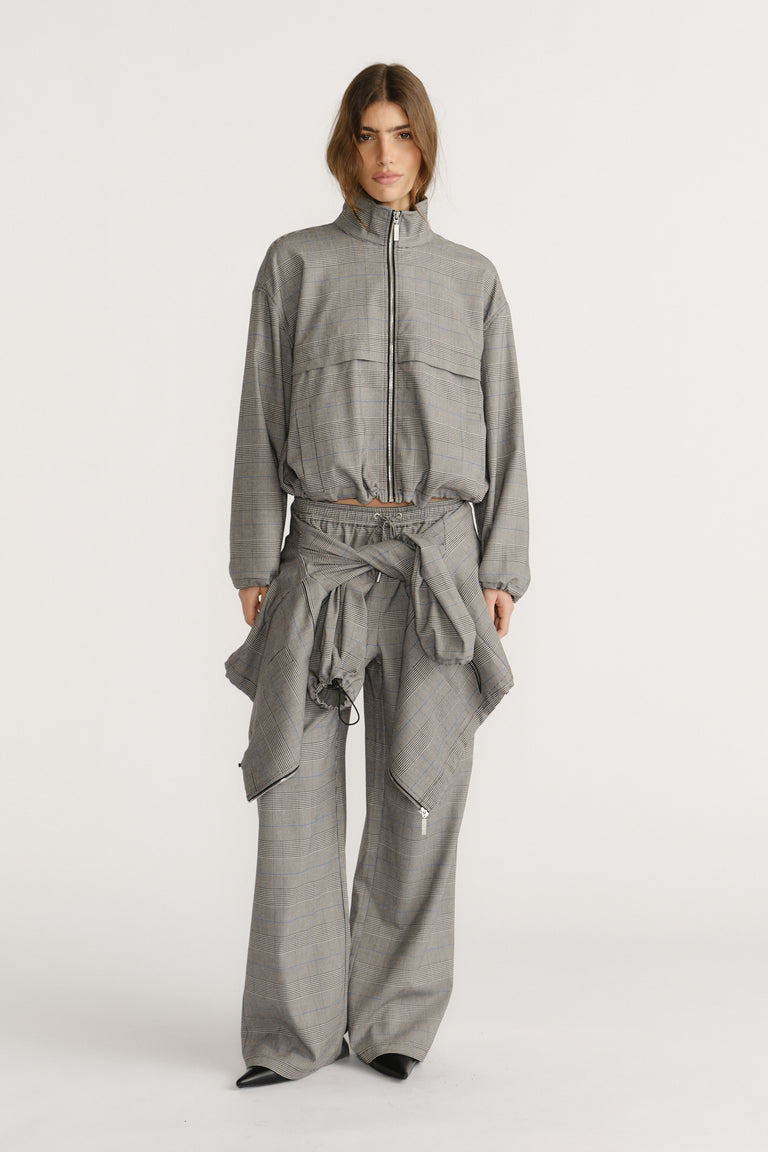 Woman wearing a relaxed fit check jacket and matching wide-leg pants with a tied jacket detail at the waist