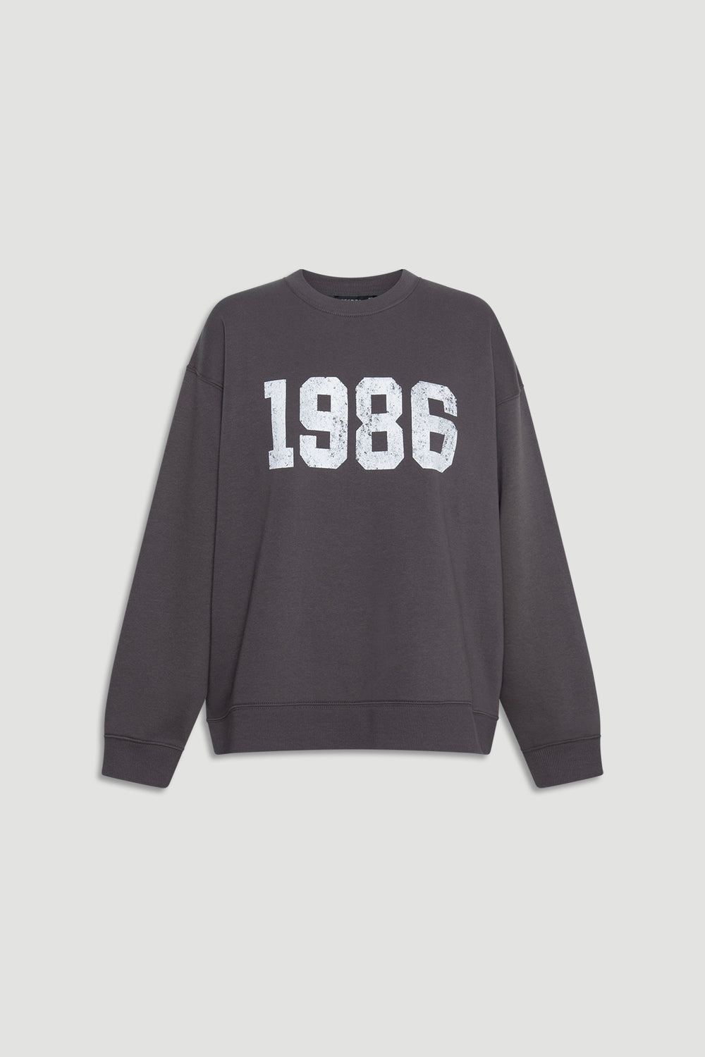 Dark grey crew neck sweatshirt with white vintage-style 1986 print and ribbed cuffs for a relaxed casual outfit