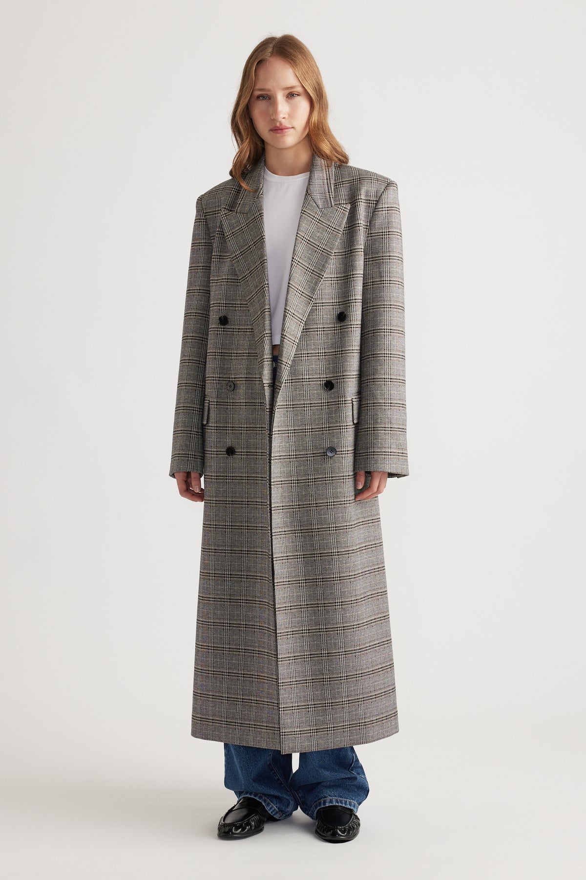 Woman wearing Ella Blazer Coat in long checked fabric with double-breasted buttons and structured shoulders for a polished look