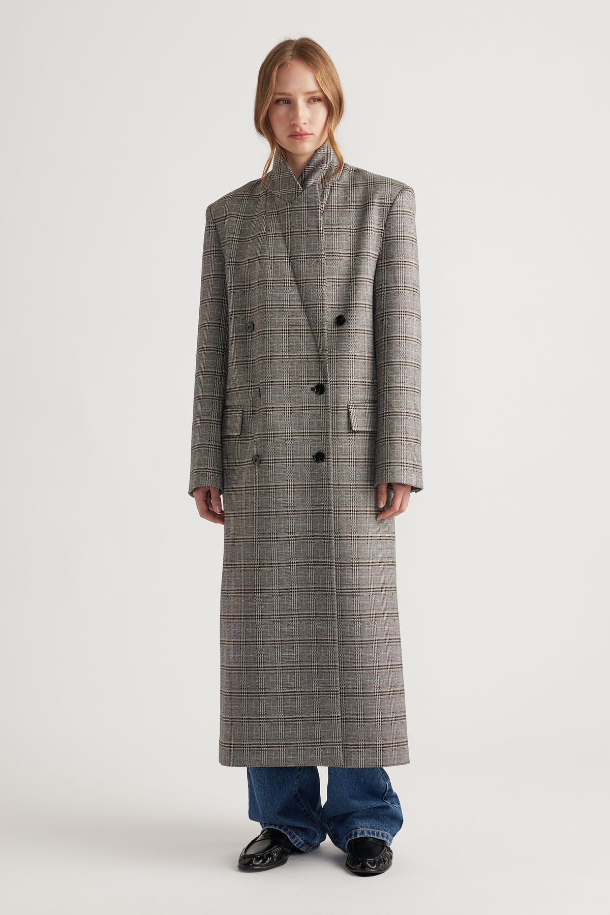 Woman wearing Ella Blazer Coat in a long, tailored checked pattern with double-breasted buttons and structured shoulders