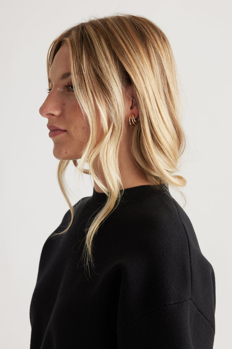 Woman wearing Cat Earring Multi Pack with layered gold-tone hoops, styled with loose waves and a black crew neck top.