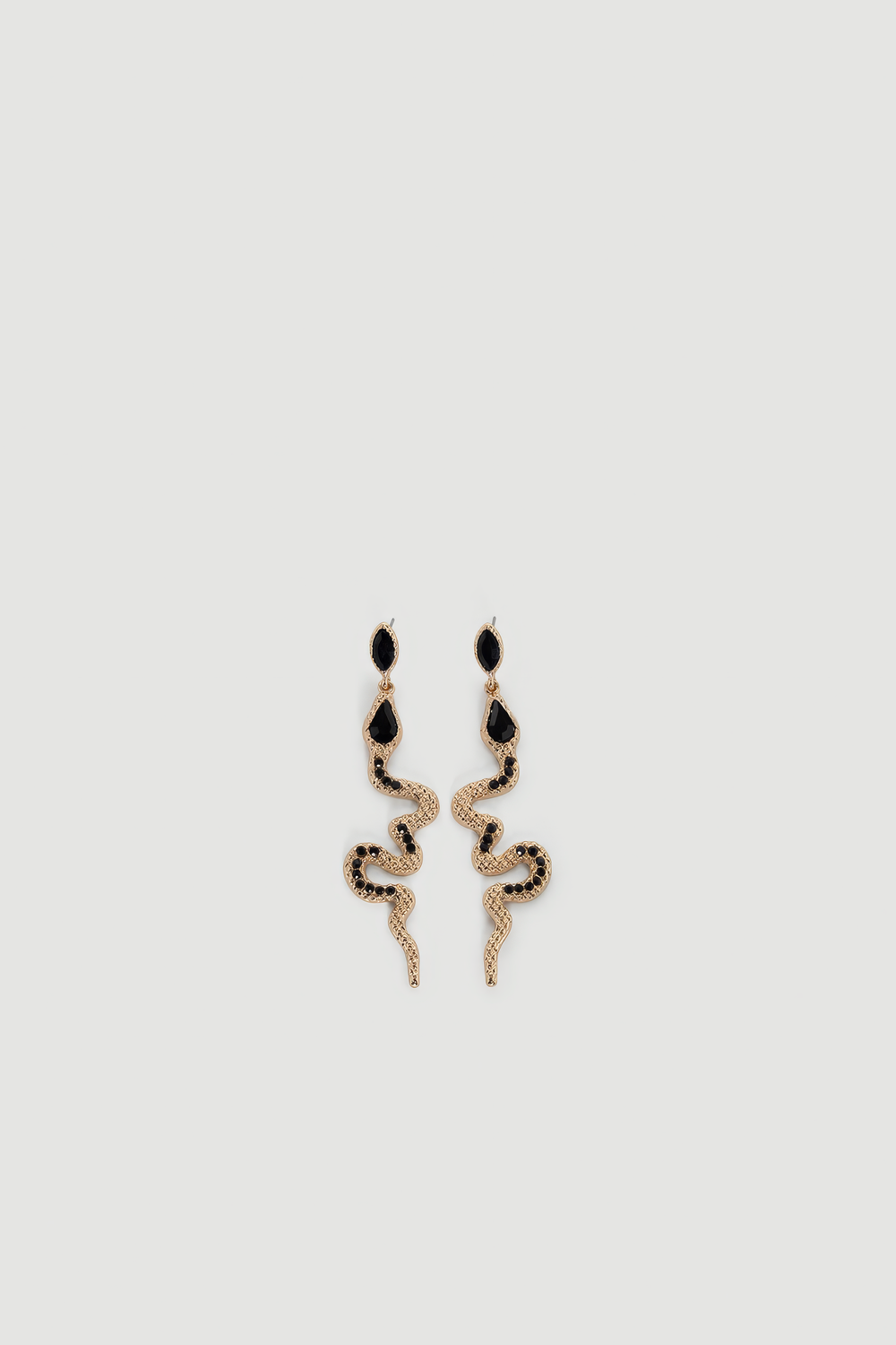 Gold-tone snake-shaped drop earrings with black gemstone accents and textured detailing on light background