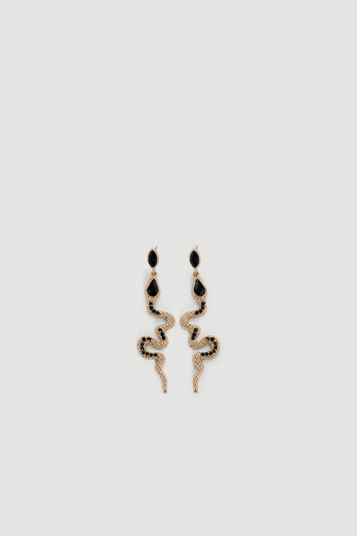 Gold-tone snake-shaped drop earrings with black gemstone accents and textured detailing on light background