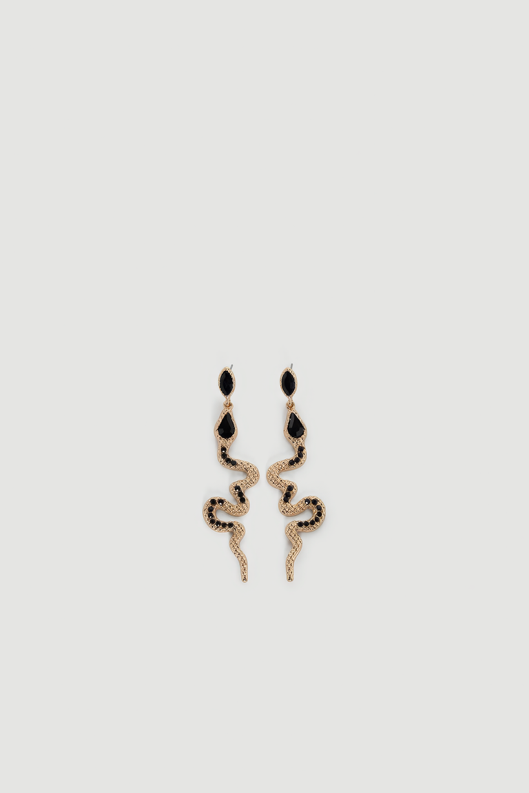 Gold-tone snake-shaped drop earrings with black gemstone accents and textured detailing on light background