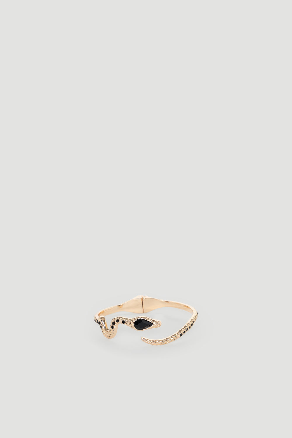 Delicate gold cuff bracelet shaped like a snake with black stone accents for a bold, stylish statement accessory