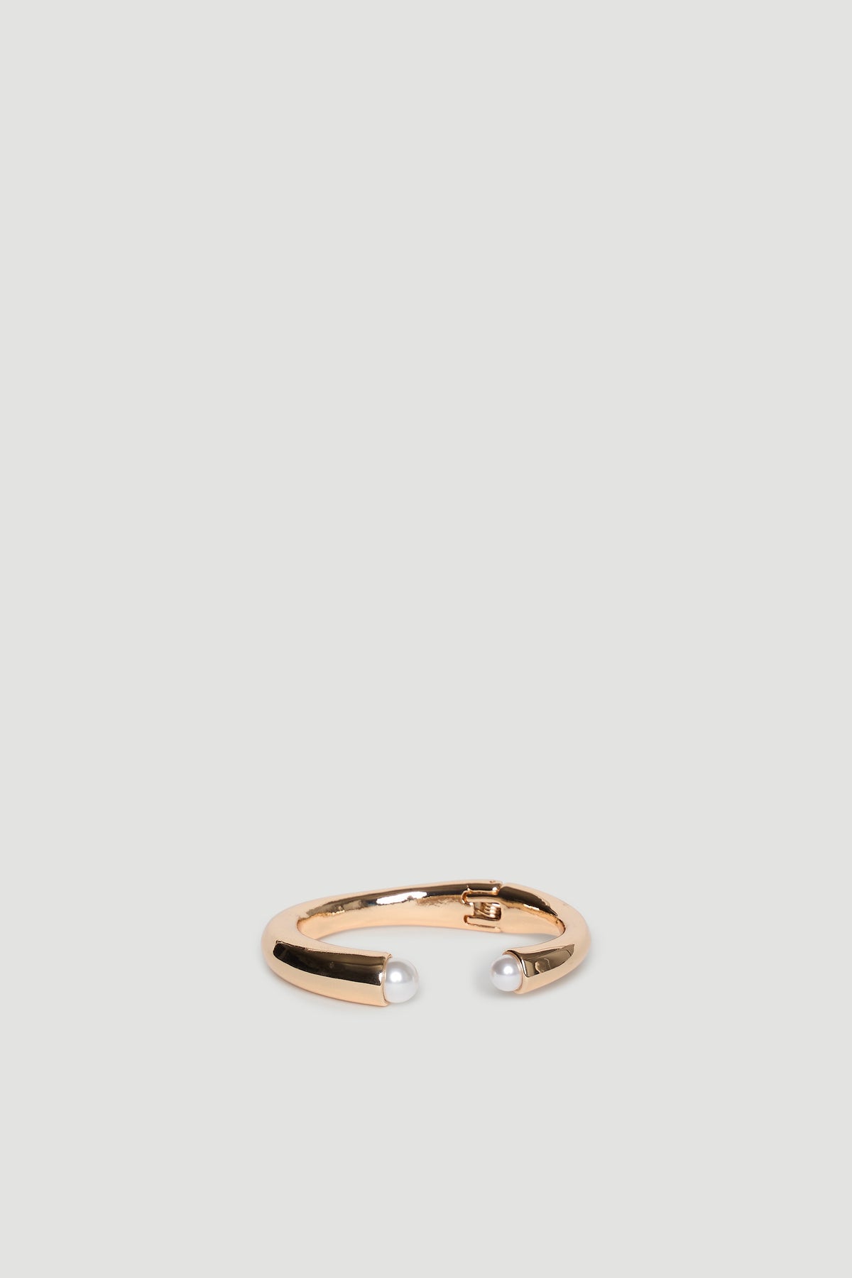 Gold open cuff bracelet featuring two delicate pearl accents at each end
