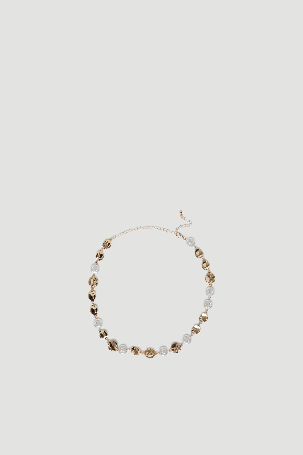Delicate gold chain necklace featuring irregular molten-style links paired with clear bead accents for a modern look