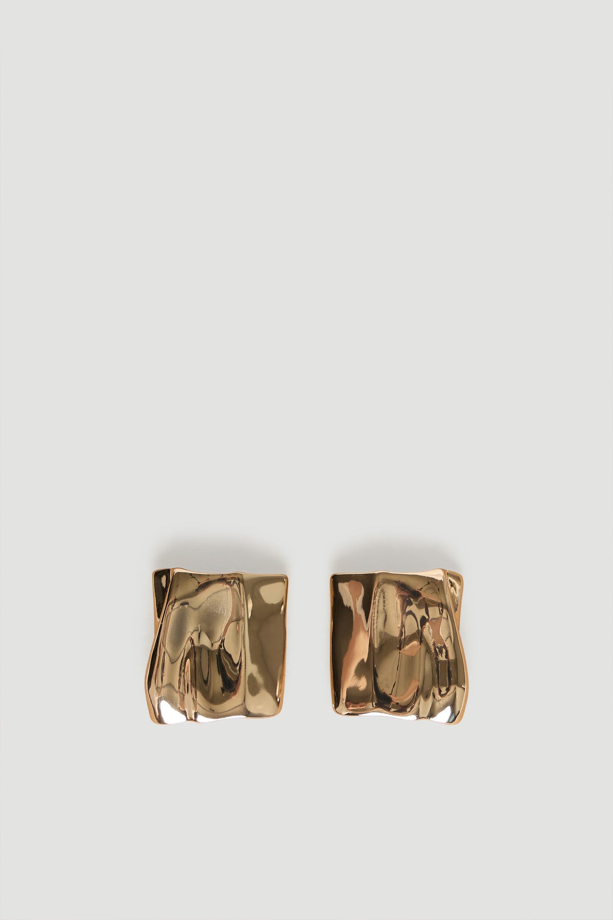 Pair of polished gold-tone rectangular stud earrings with an artistic, slightly irregular surface texture