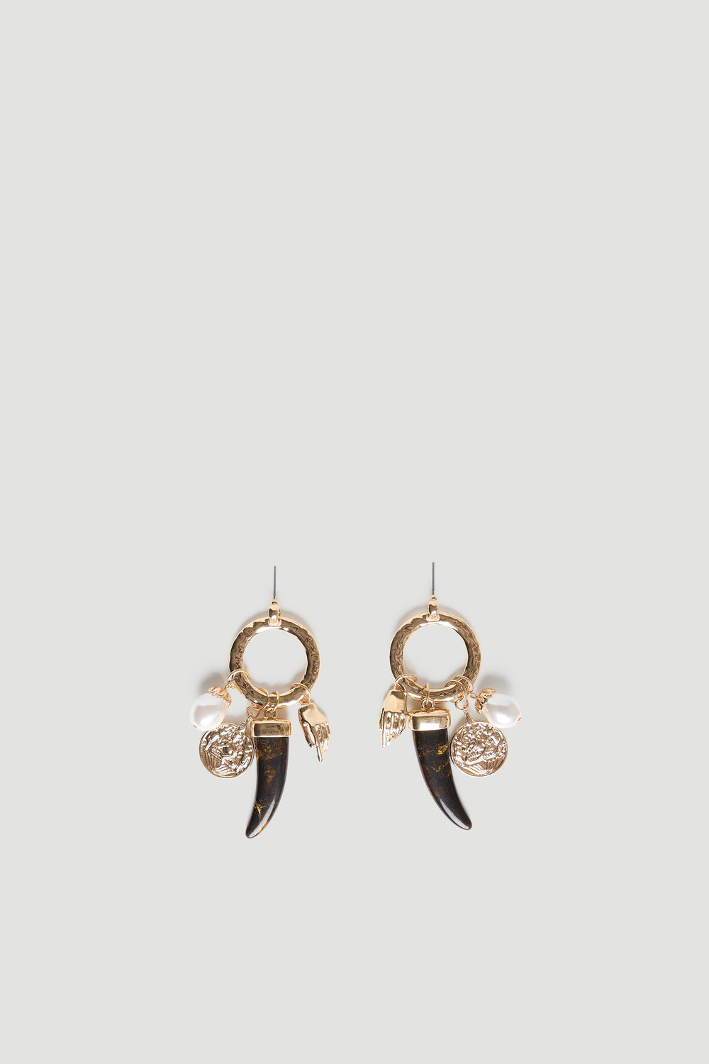 Gold hoop earrings with textured charms including a pearl, coin, hand, and black horn for a unique statement accessory.