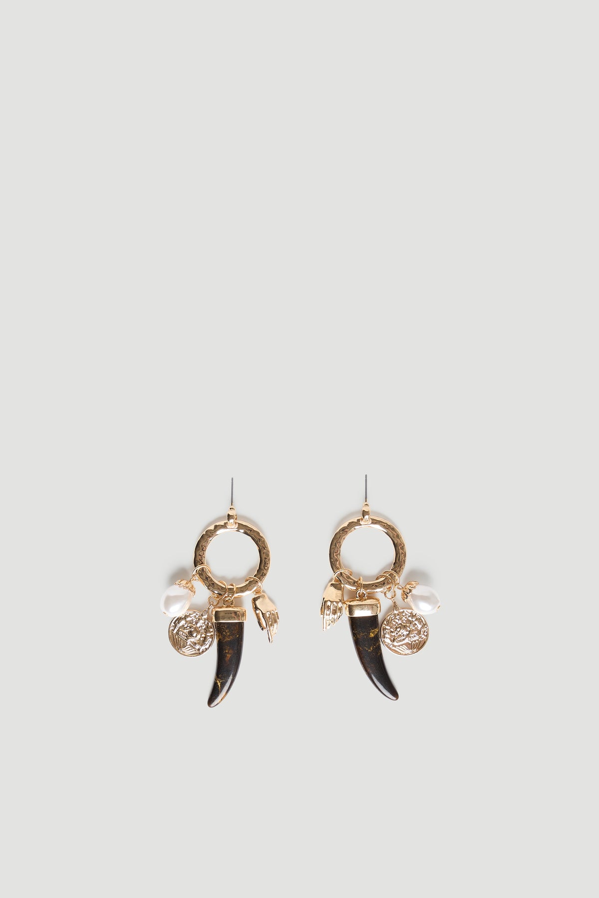 Gold hoop earrings with textured charms including a pearl, coin, hand, and black horn for a unique statement accessory.