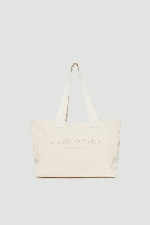 Structured cream tote bag with wide shoulder straps and subtle front logo embroidery detail