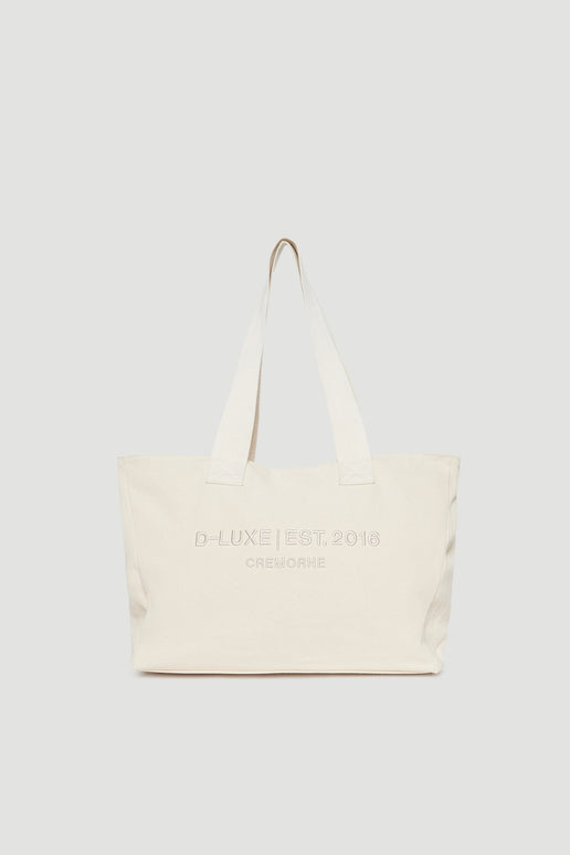 Structured cream tote bag with wide shoulder straps and subtle front logo embroidery detail