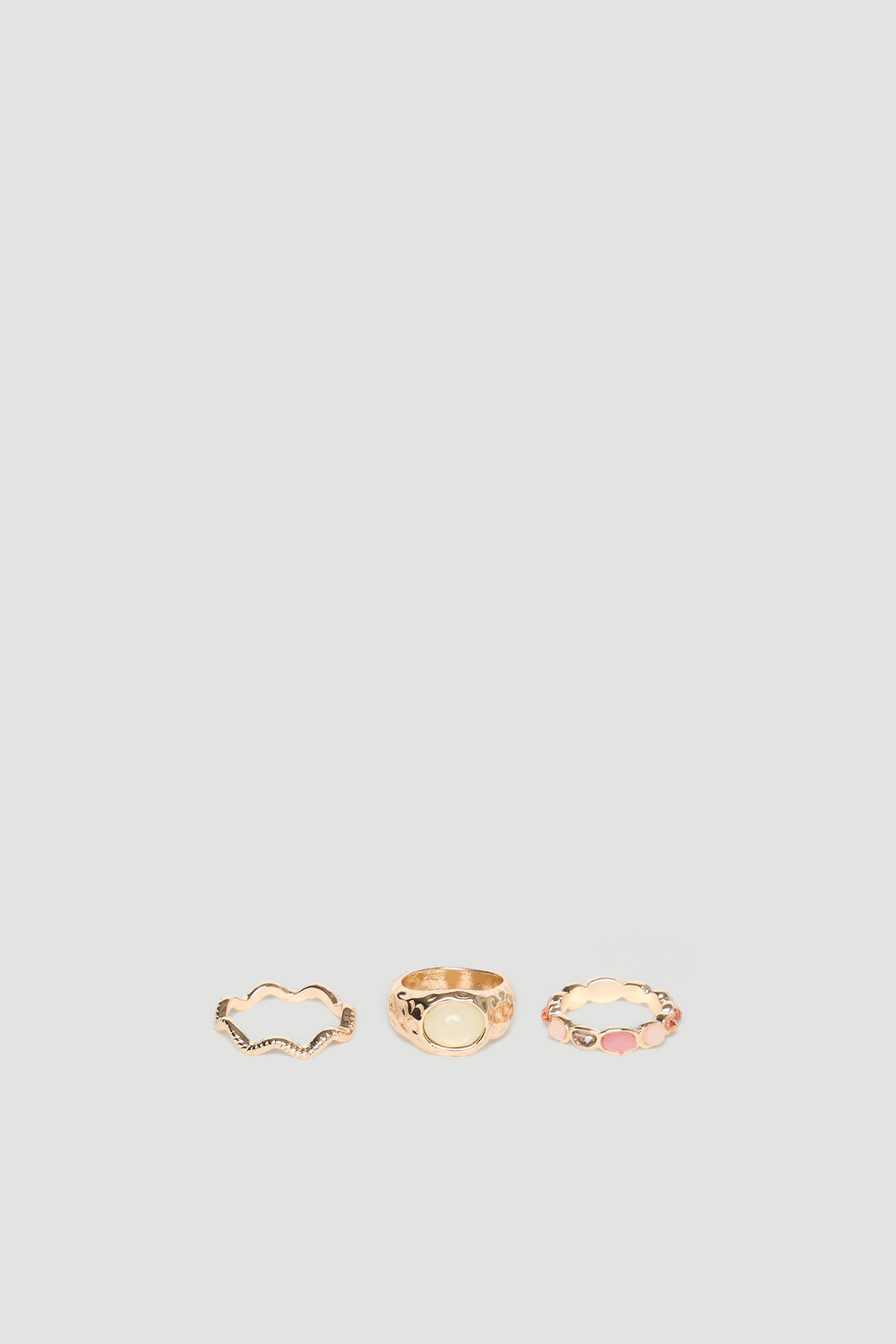 Set of three delicate gold rings featuring textured and stone-accented designs for a versatile, elegant look.
