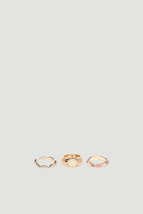 Set of three delicate gold rings featuring textured and stone-accented designs for a versatile, elegant look.