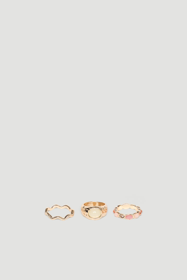 Set of three delicate gold rings featuring textured and stone-accented designs for a versatile, elegant look.