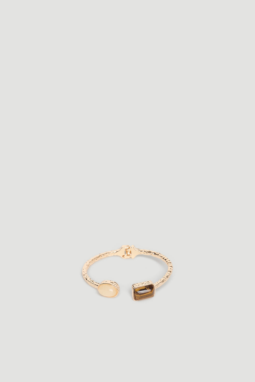 Delicate gold cuff bracelet featuring two polished stone accents with a textured band for a refined look.