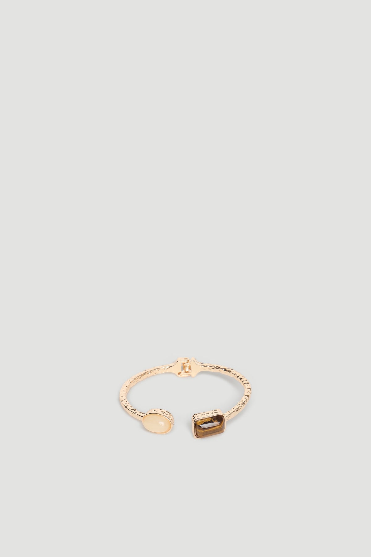 Delicate gold cuff bracelet featuring two polished stone accents with a textured band for a refined look.