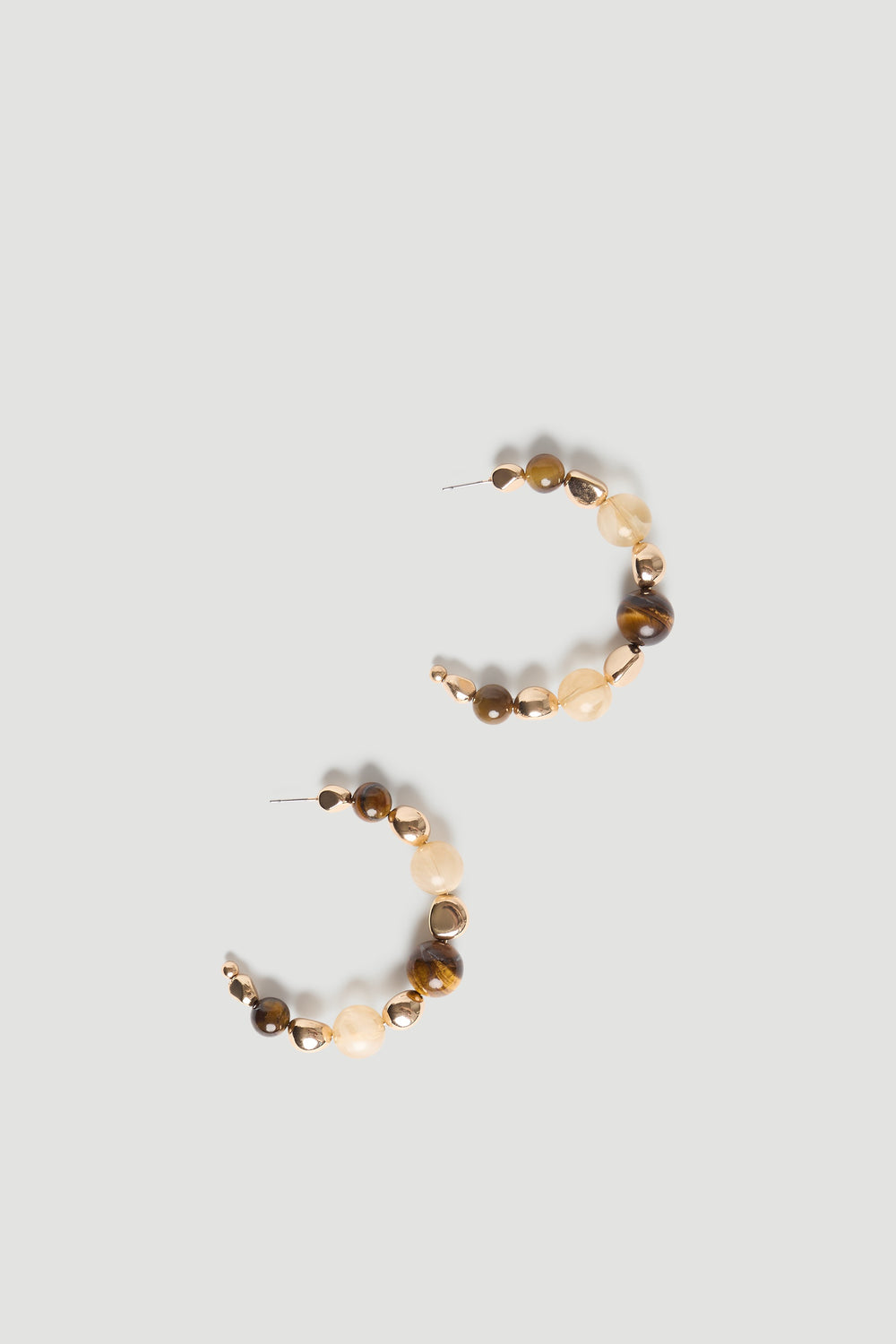 Curved hoop earrings featuring polished gold and natural stone beads in warm earthy tones for a chic, effortless look.