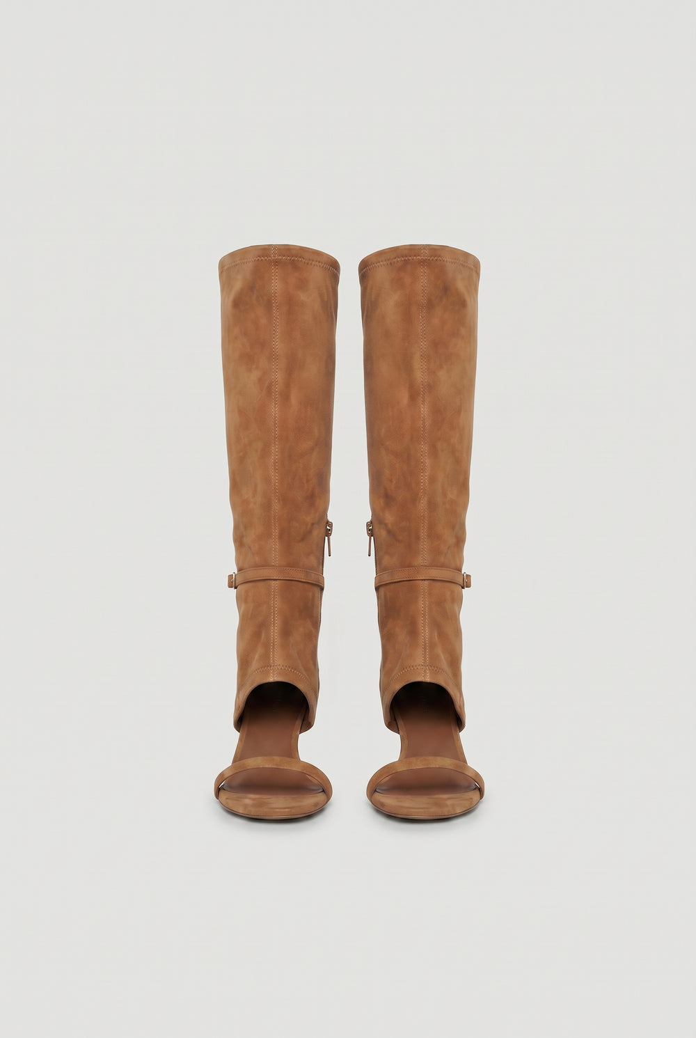 Pair of tan knee-high heels featuring an open toe and subtle buckle detail for a modern, stylish look.