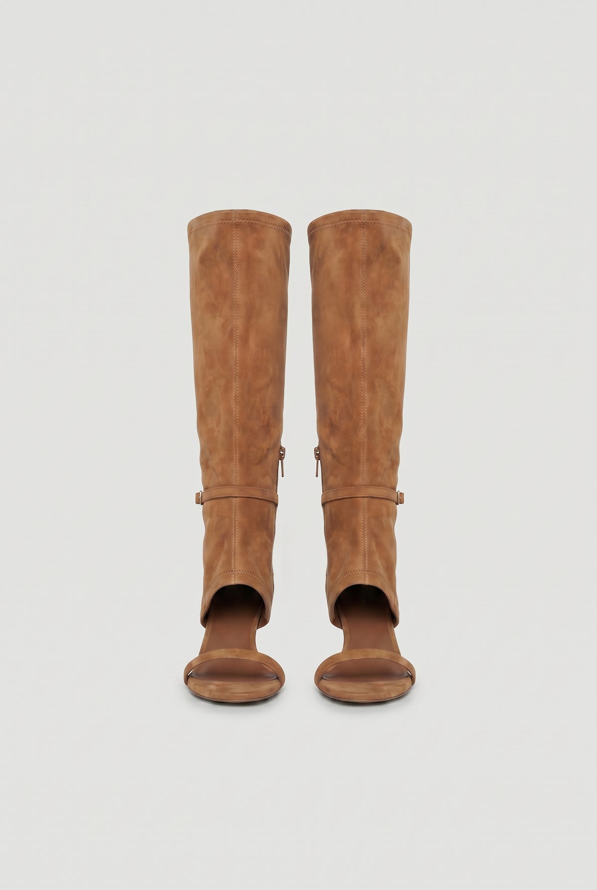 Pair of tan knee-high heels featuring an open toe and subtle buckle detail for a modern, stylish look.