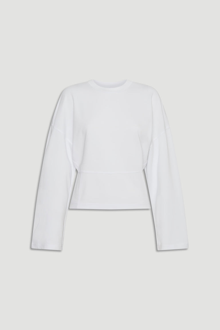 Minimalist white long sleeve top with dropped shoulders and a slightly tapered waist for a modern silhouette