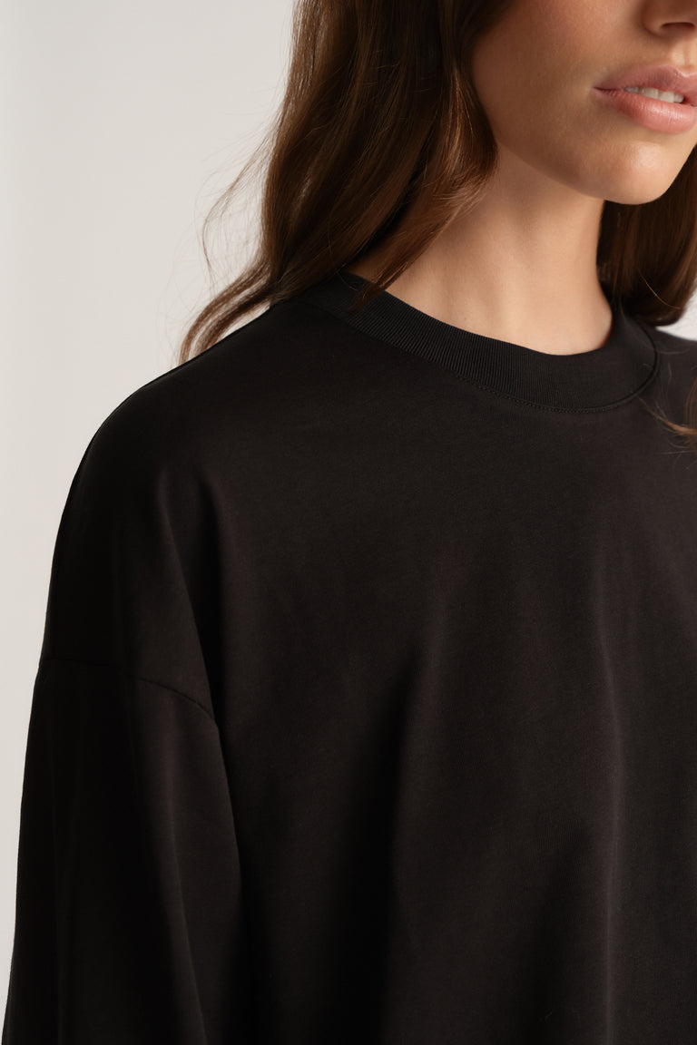 Woman wearing a black oversized long sleeve crew neck tee
