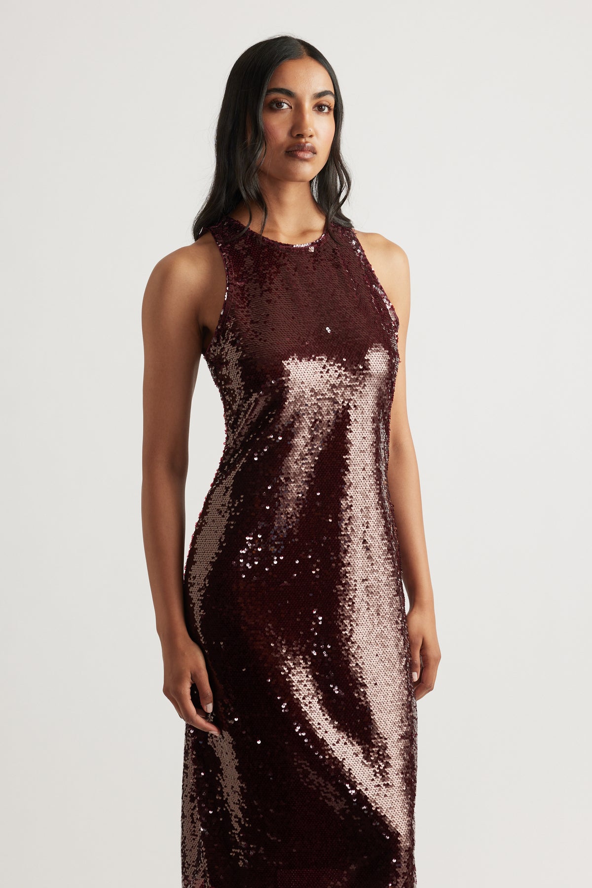 Sleeveless midi dress in deep plum covered in shimmering sequins, featuring a high neckline and sleek silhouette.