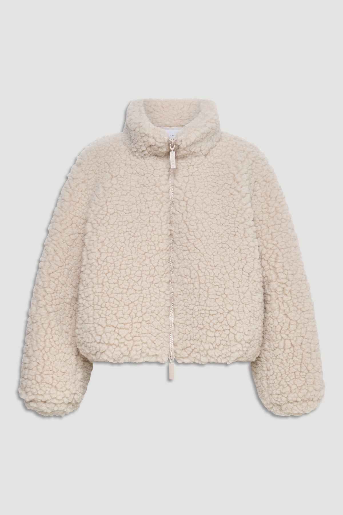 Cream-colored sherpa bomber jacket with high neck, full zipper, and relaxed fit for cozy layering.