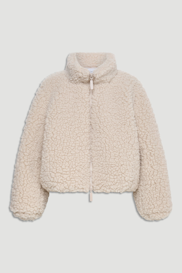 Cream-colored sherpa bomber jacket with high neck, full zipper, and relaxed fit for cozy layering.
