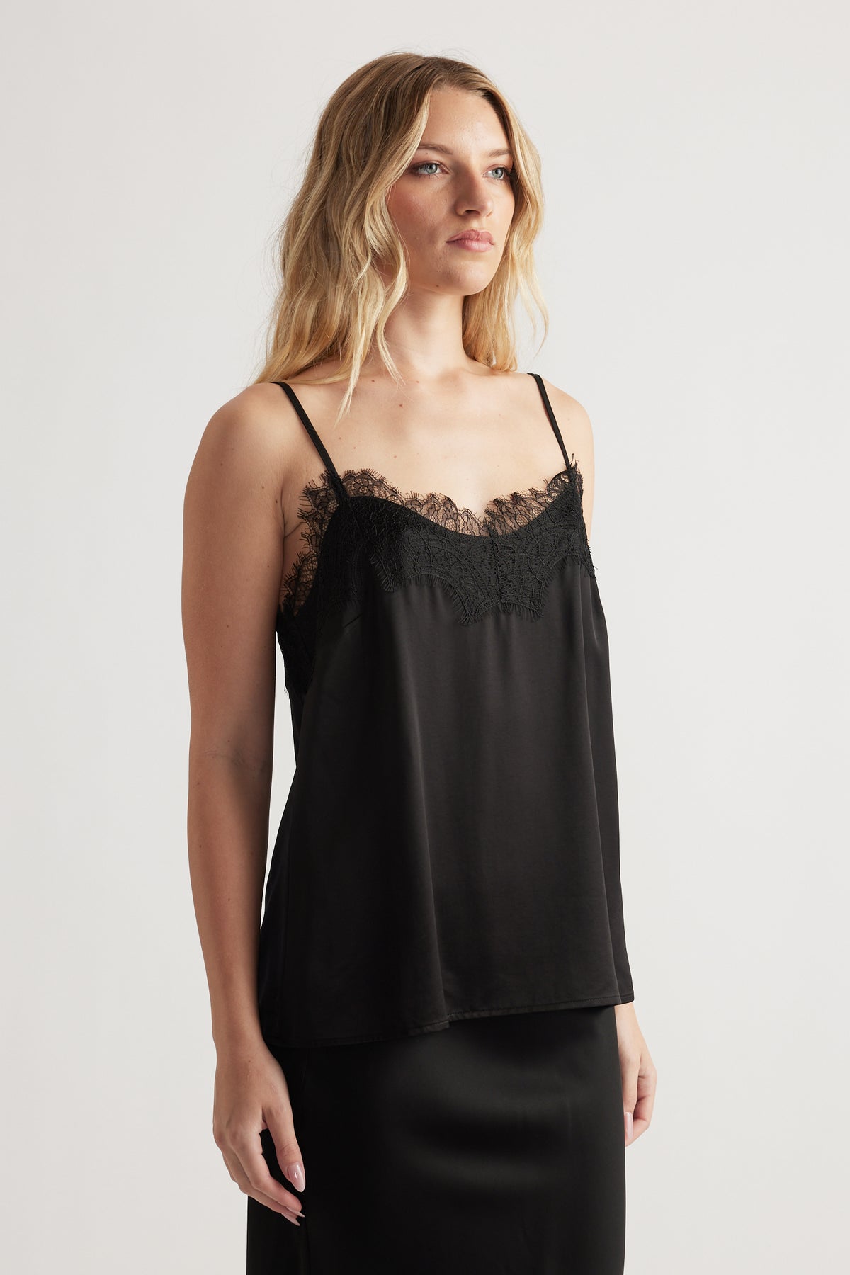 Black lace-trimmed cami with delicate spaghetti straps and a smooth, flowing silhouette for effortless style.