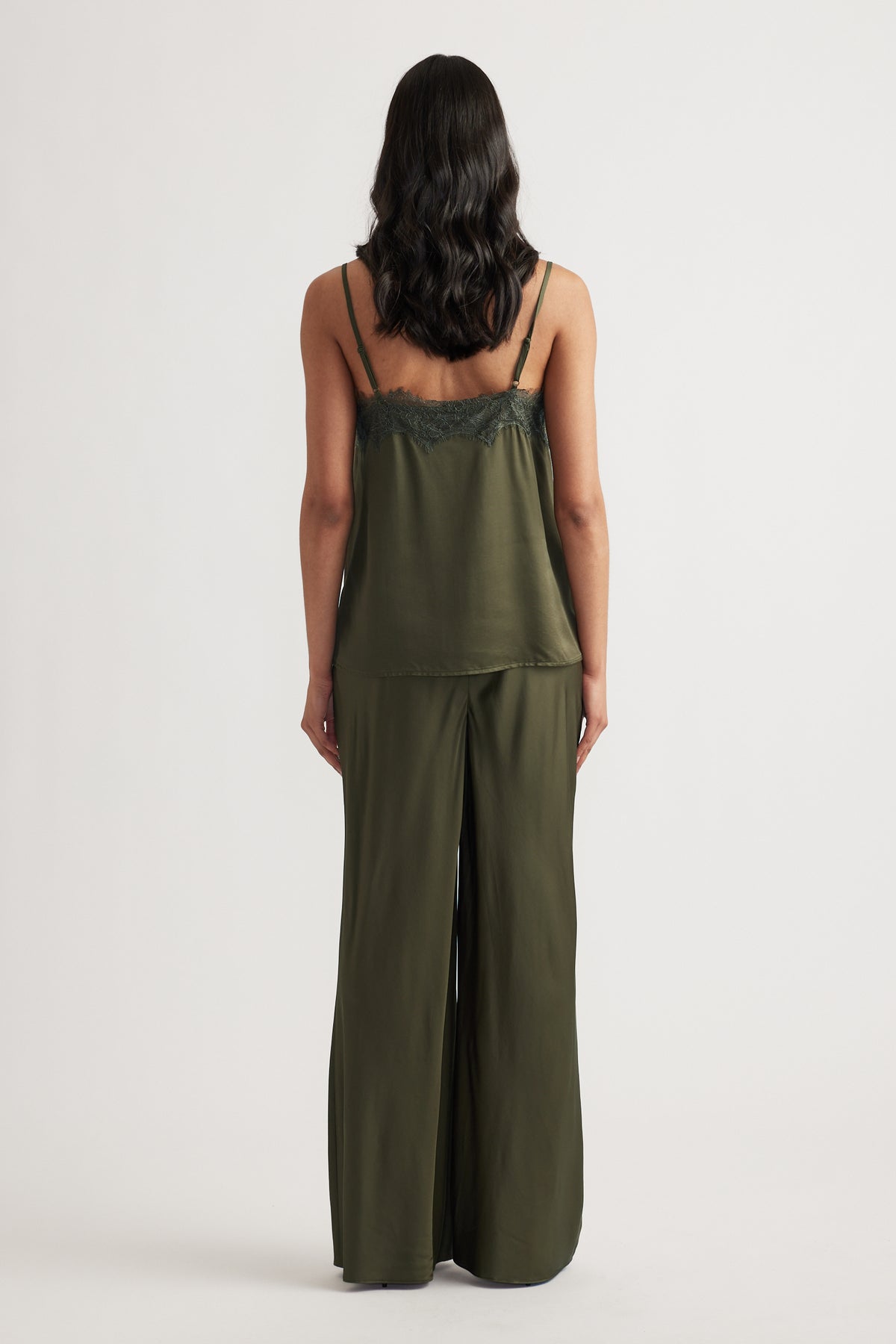 Woman wearing an olive lace-trimmed cami with matching wide-leg pants, shown from the back against a neutral background