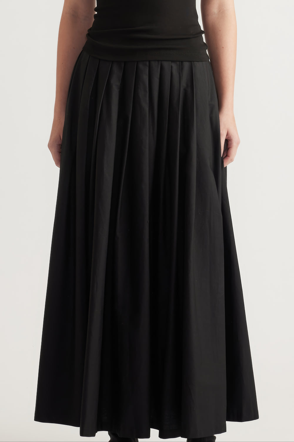 Black pleated ankle length A line skirt styled with a fitted top