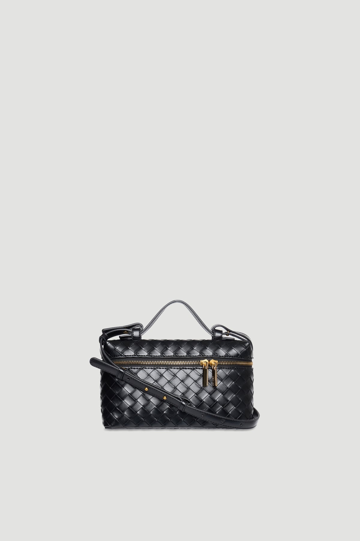 Compact black woven vanity bag with detachable strap and gold zipper hardware on light background