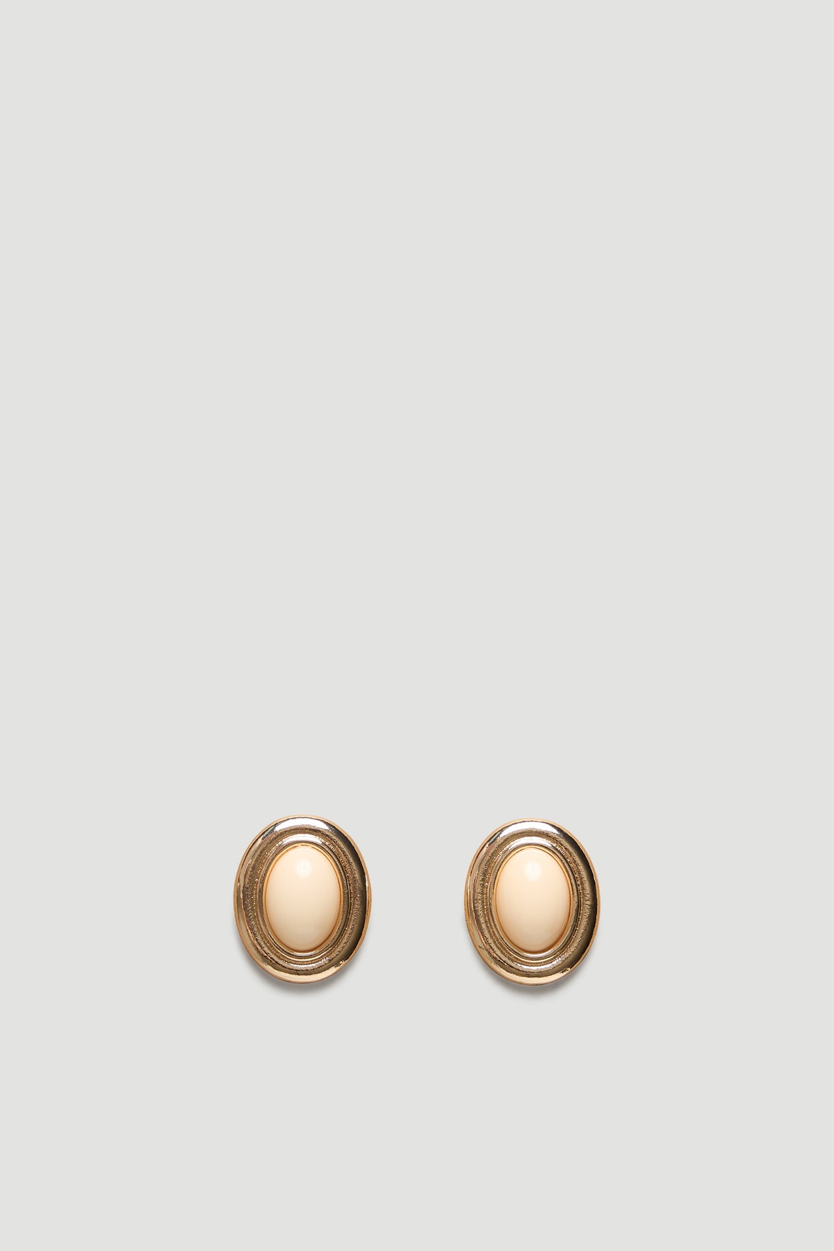 Oval gold-tone stud earrings featuring a smooth cream center for a timeless, elegant accessory look.