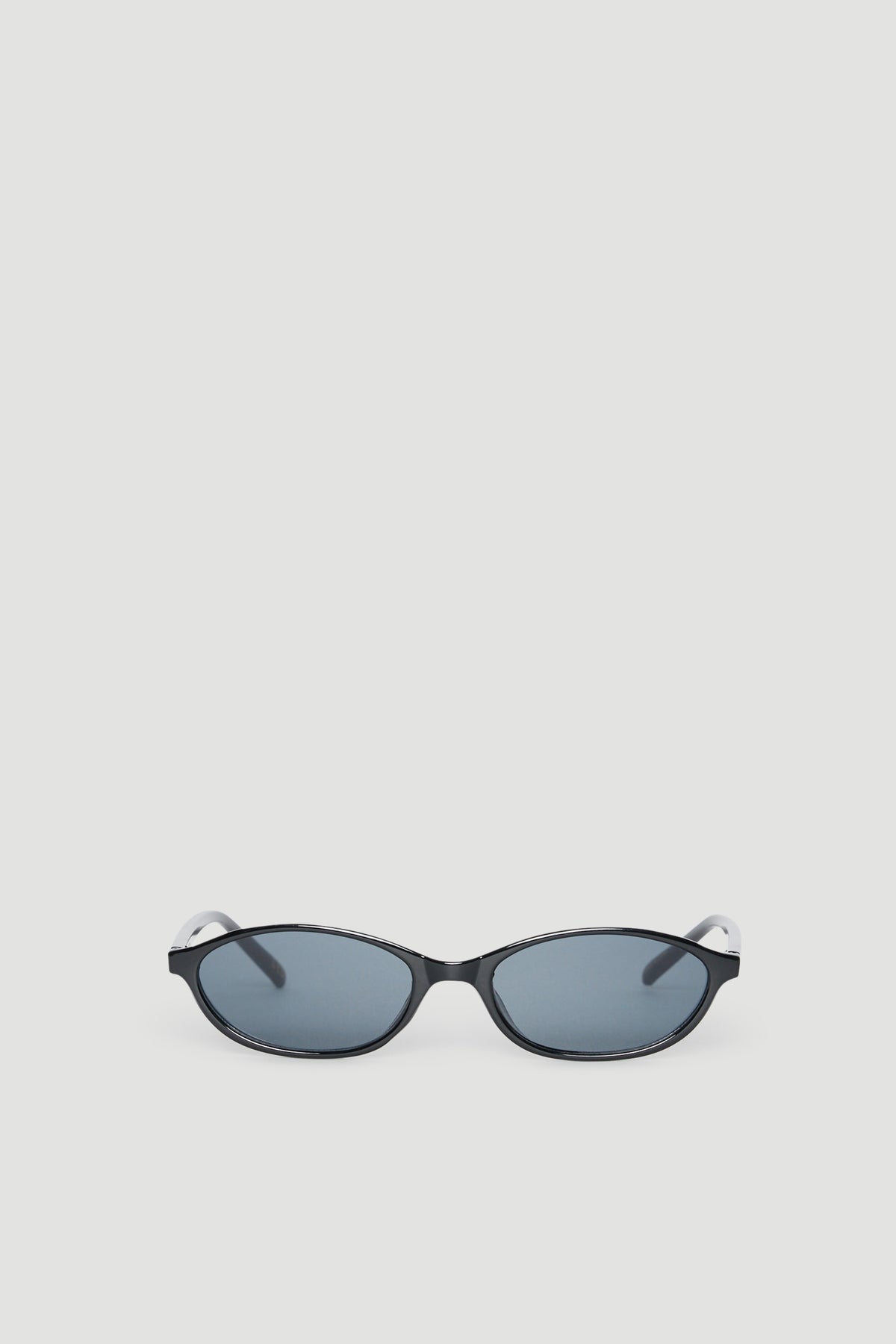 Slim black cat eye sunglasses with tinted lenses providing 100% UV protection on a neutral background