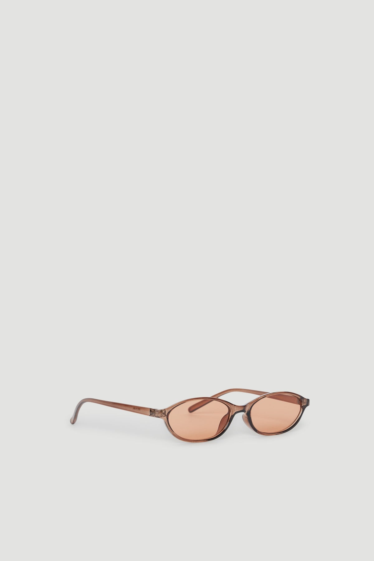 Slim frame sunglasses with tinted lenses and a subtle cat eye shape offering stylish UV protection.