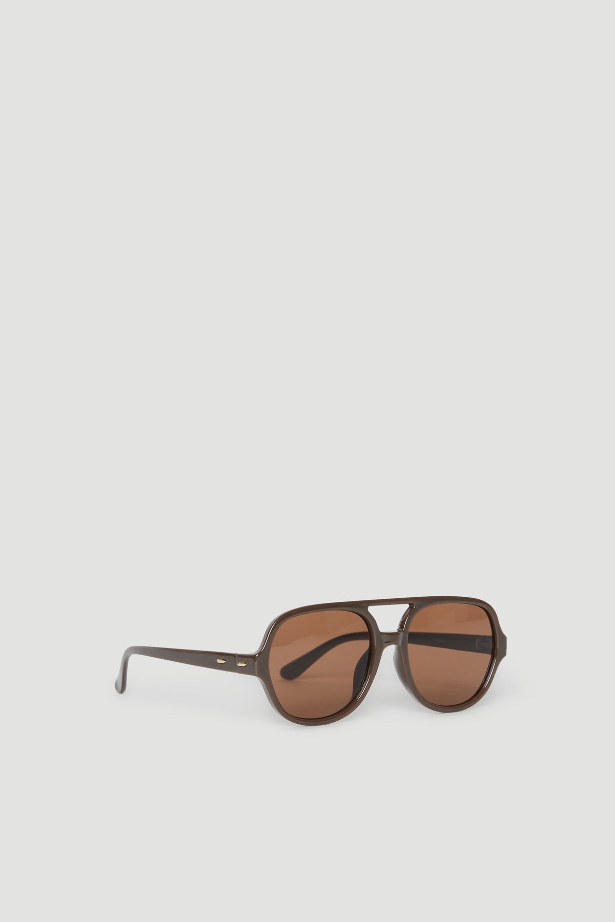 Oversized aviator sunglasses with brown tinted lenses and dark frames offering full UV protection on a neutral background
