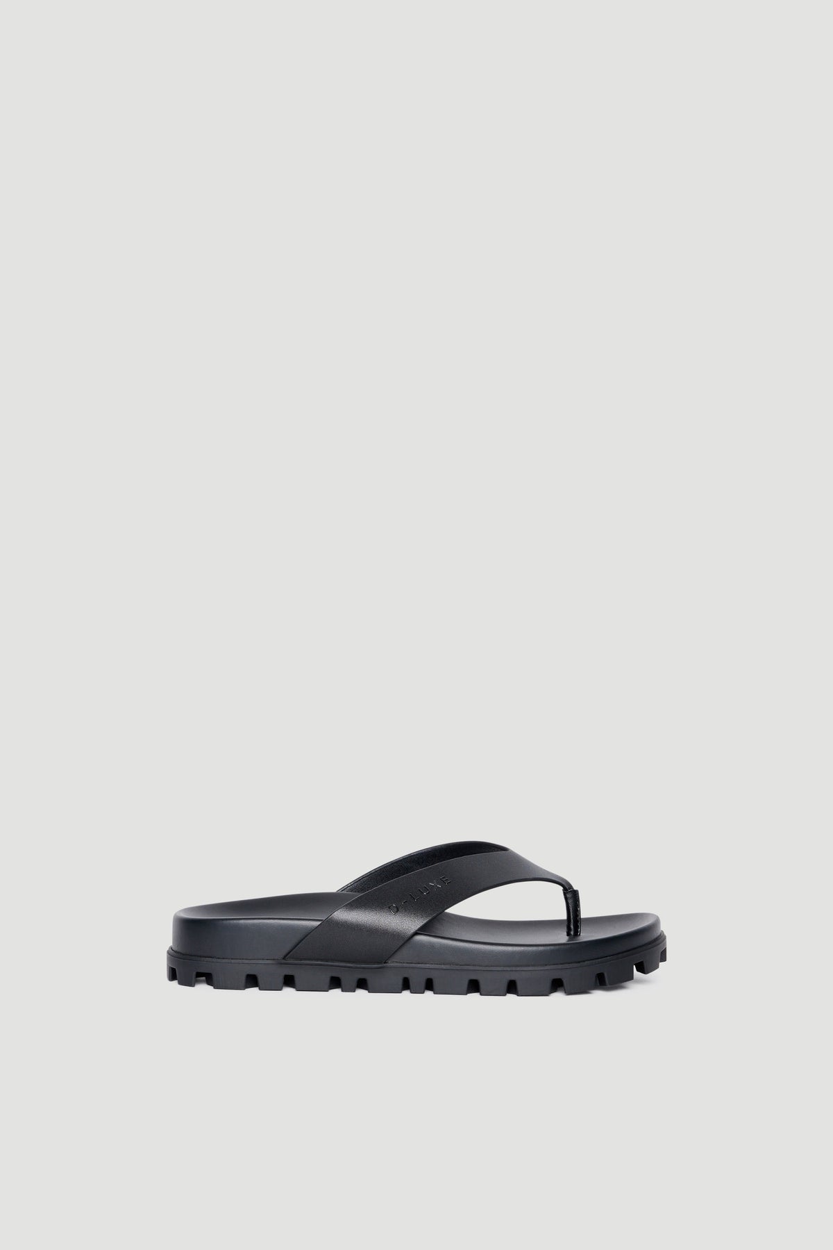 Black chunky platform thong sandal with slip-on design and textured anti-slip sole against plain background