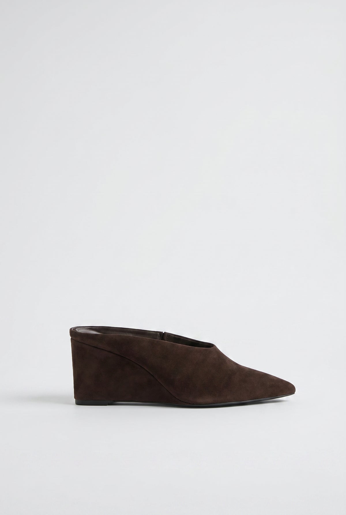 Side view of a sleek chocolate brown pointed wedge heel mule with smooth finish and clean lines.