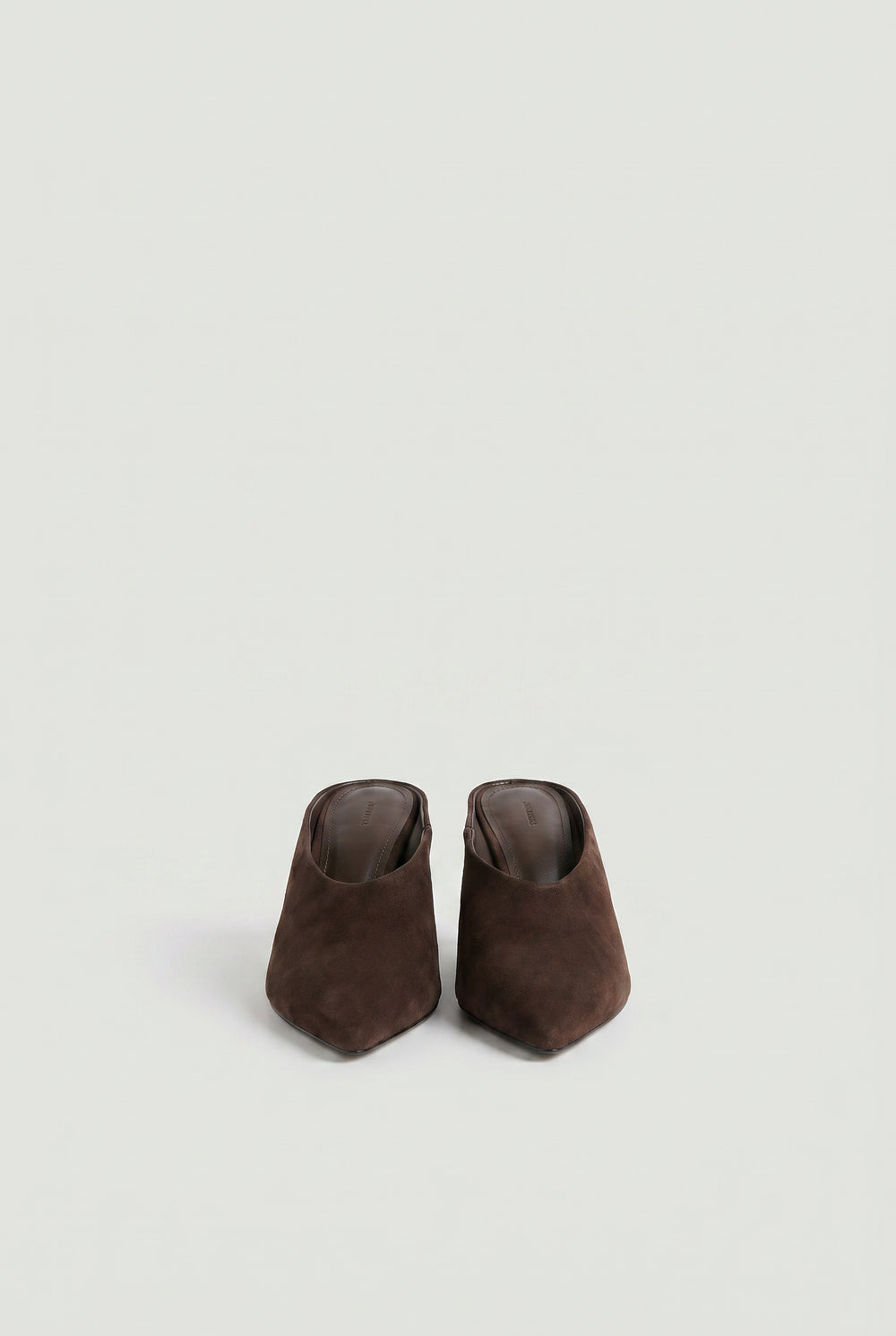 Pair of brown pointed-toe slip-on heels in a soft, matte finish against a light neutral background.