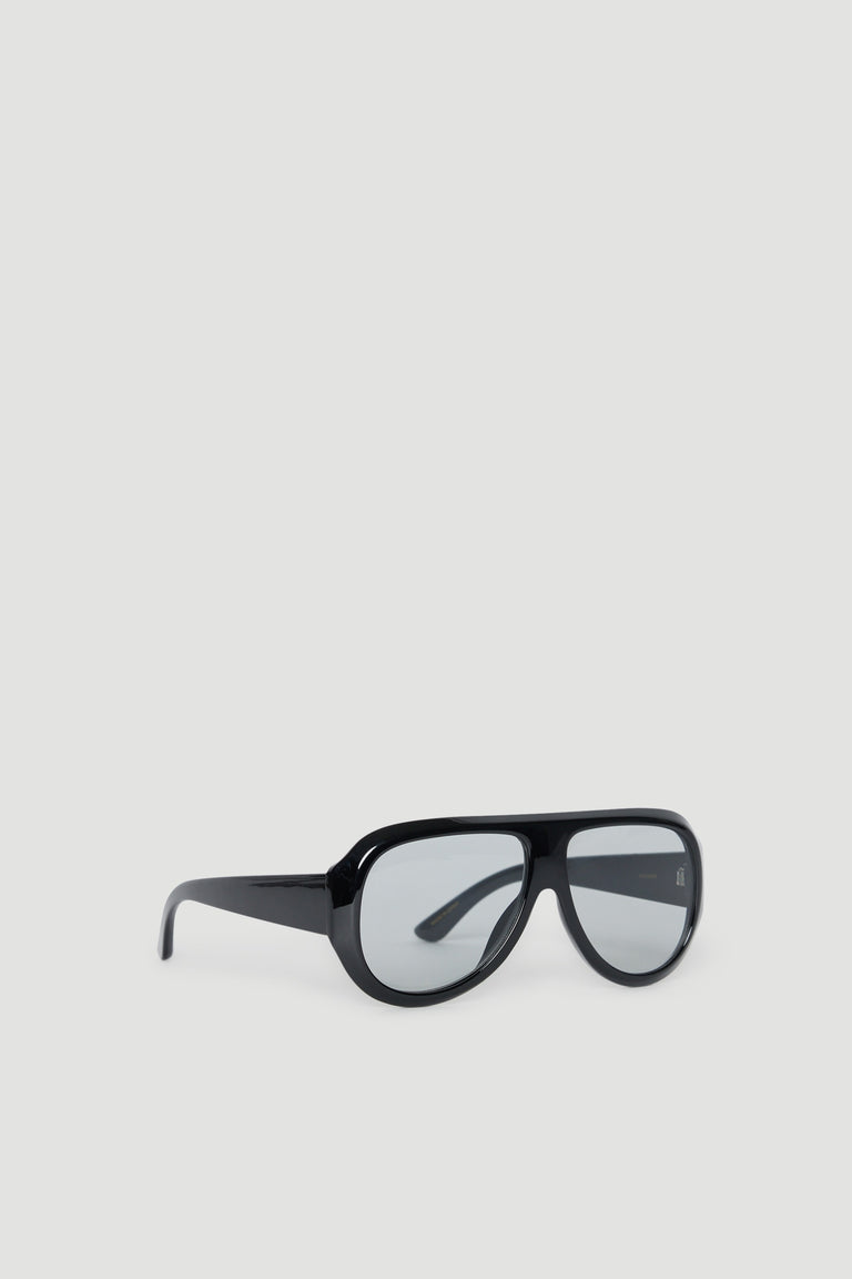 Black oversized aviator sunglasses with tinted lenses and sleek glossy frames on a neutral background