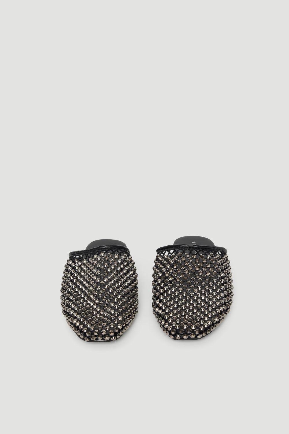 Black slip-on mules adorned with sparkling diamante studs for a bold, chic statement look.