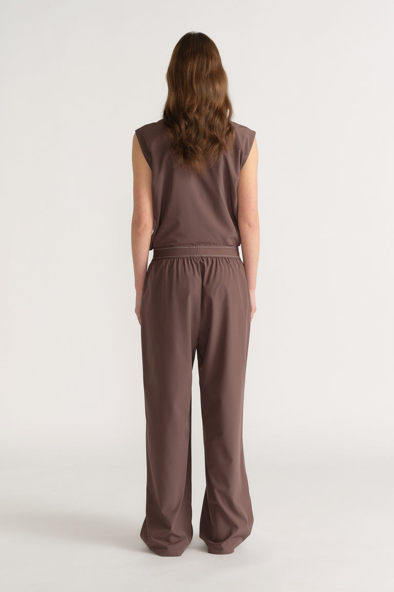Back view of a woman wearing brown wide-leg pull-on pants with an elastic waist and matching sleeveless top