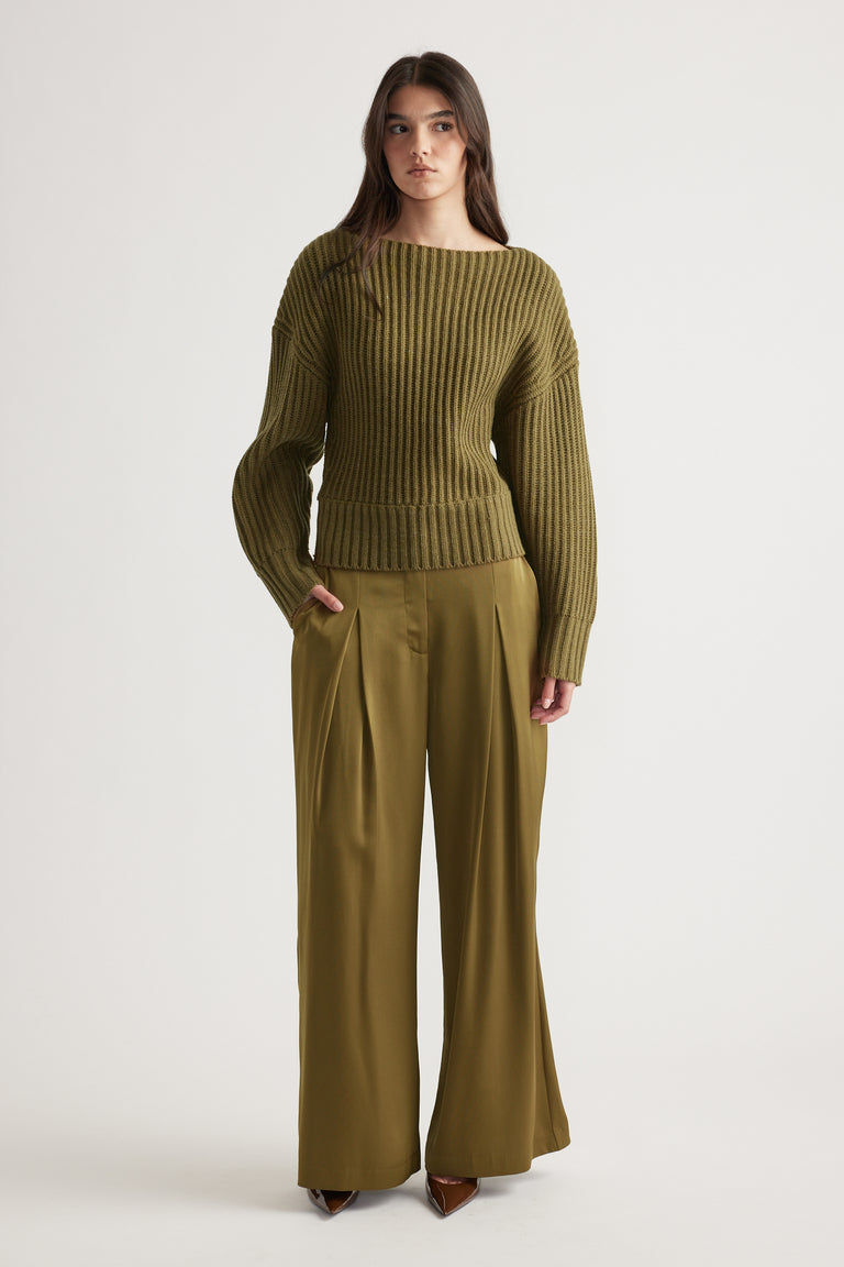 Woman wearing an olive green ribbed knit jumper with dropped shoulders paired with matching wide-leg pants