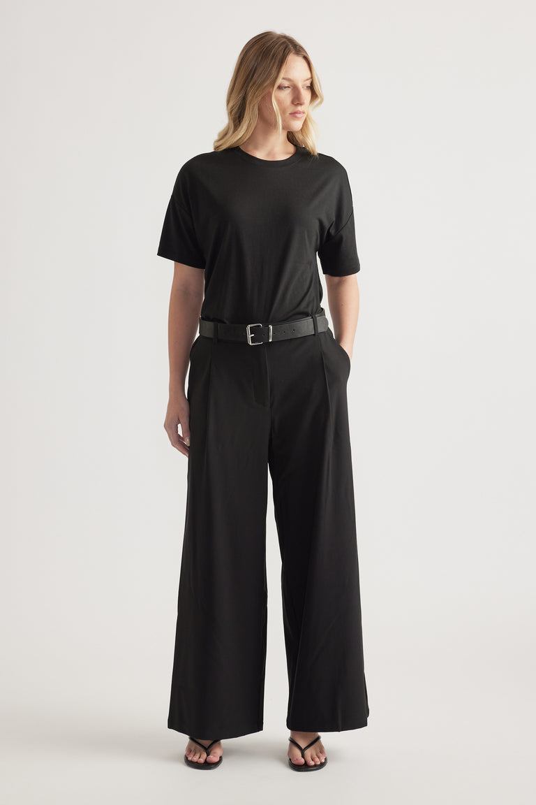 Woman wearing black high-rise wide-leg pants with a belt and relaxed black tee outfit