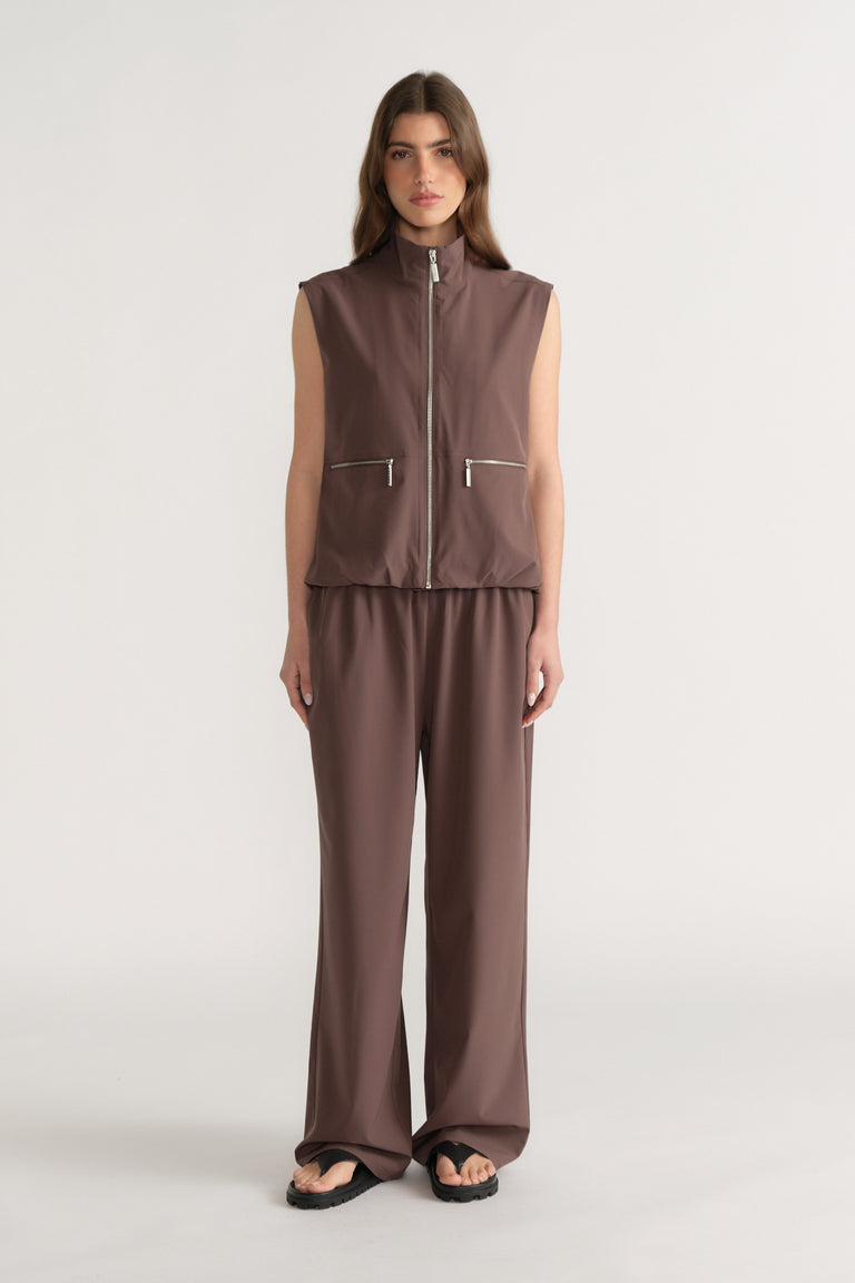 Woman wearing a brown sleeveless high neck gilet with matching wide leg pants