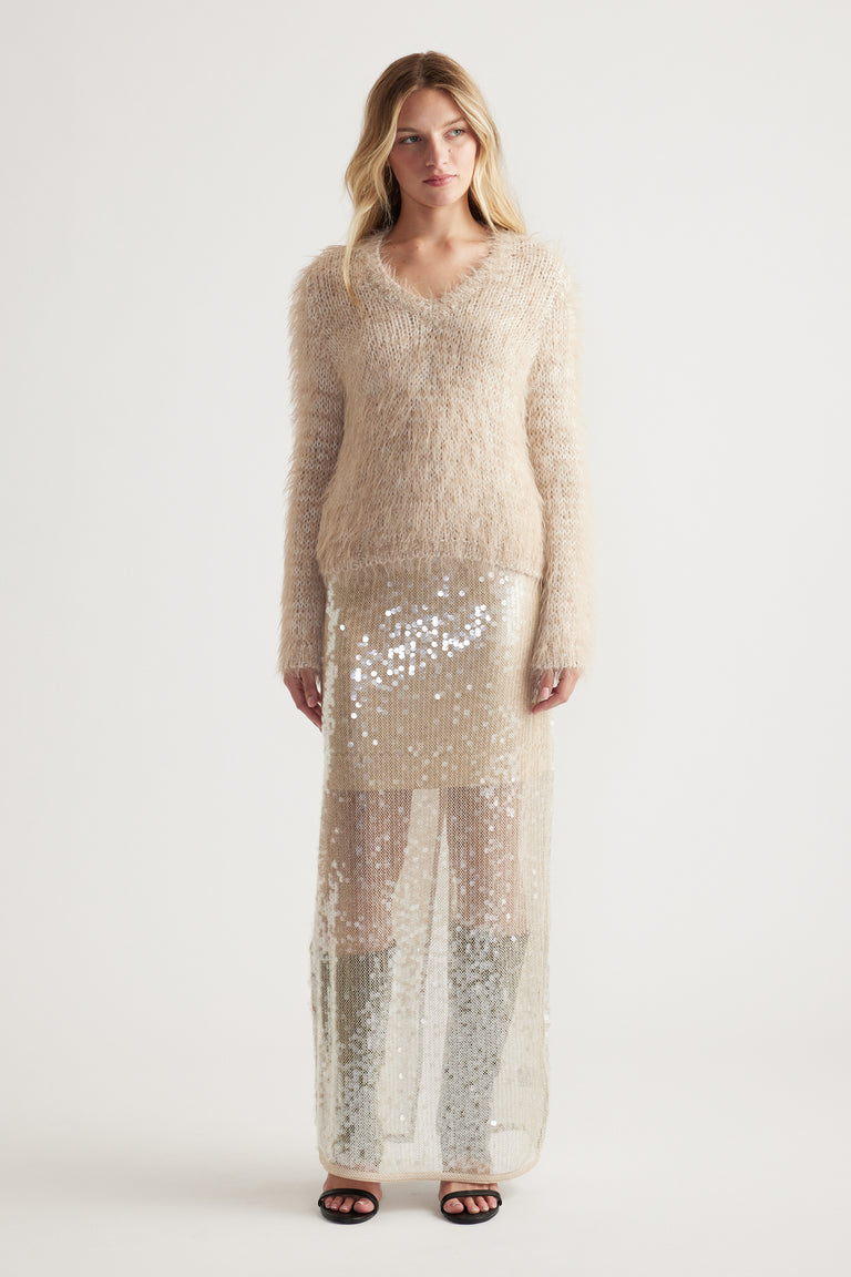 Soft beige fluffy knit jumper with V neckline paired with a long sheer sequined skirt for a chic look