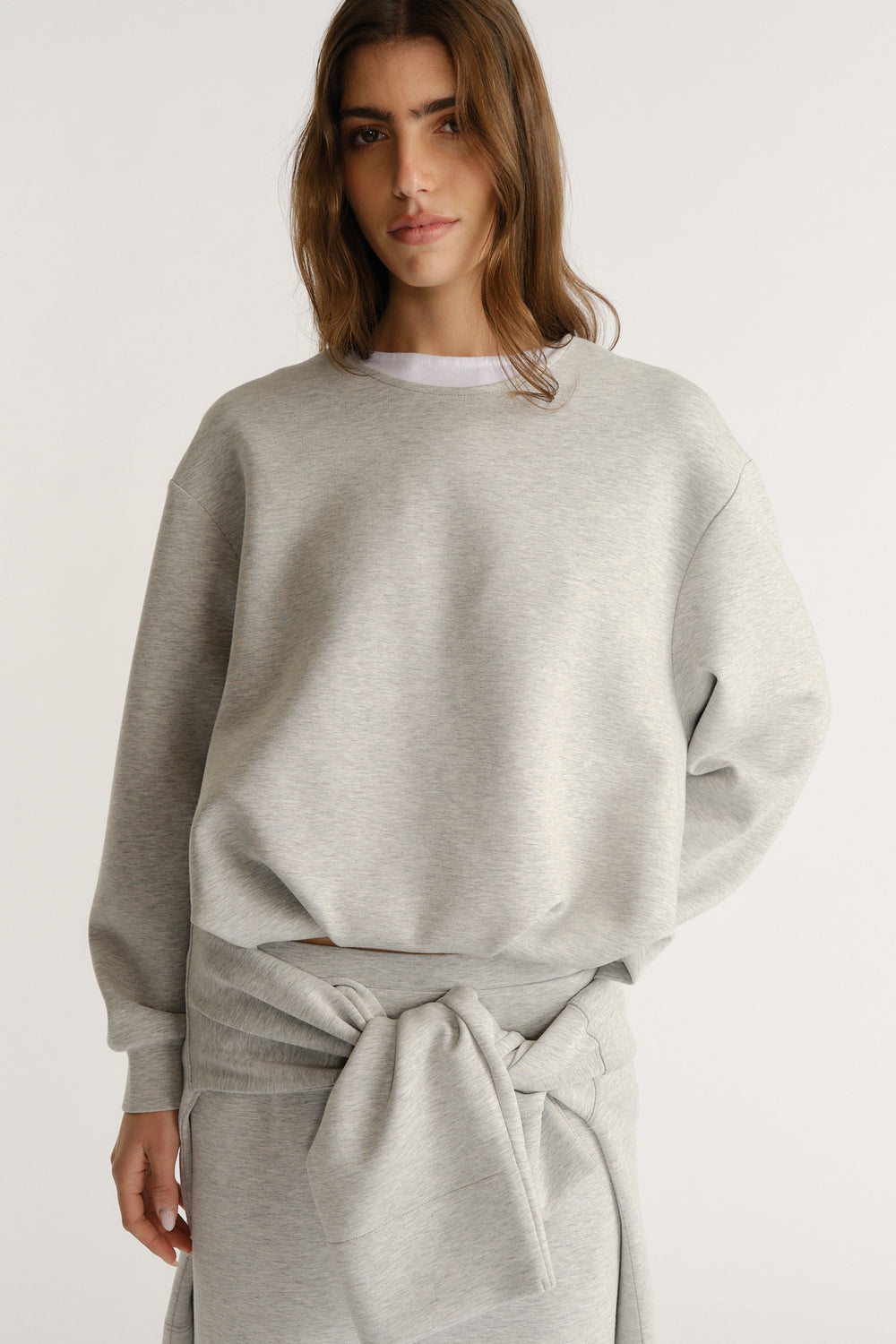 Light grey relaxed-fit sweatshirt styled with a matching tied sweatshirt for a cozy, modern layered look