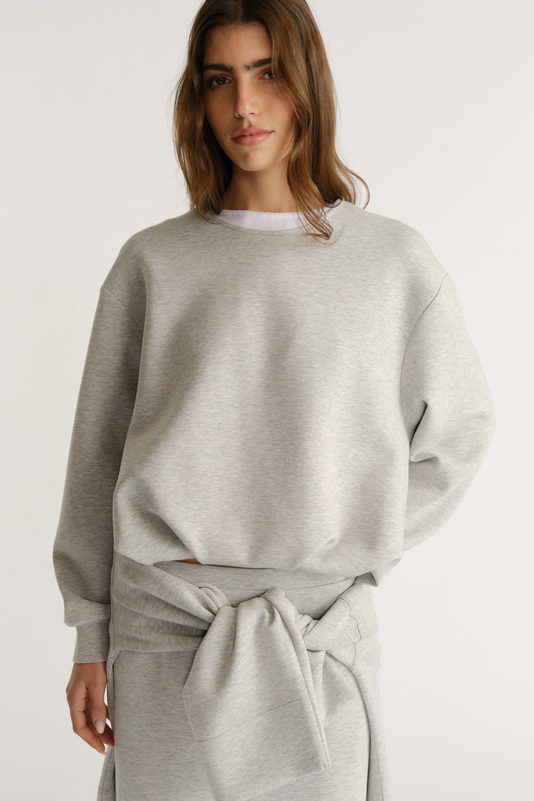 Light grey relaxed-fit sweatshirt styled with a matching tied sweatshirt for a cozy, modern layered look